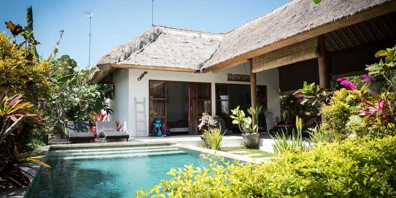 Villa dengan kolam renang di tengah taman tropis